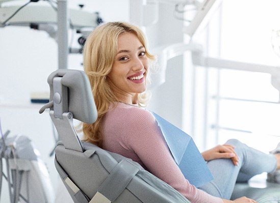 A beautiful, smiling woman sitting in a dentist chair