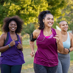 Group of women smiling while jogging in park