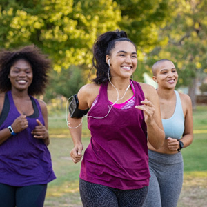 Group of women smiling while jogging in park