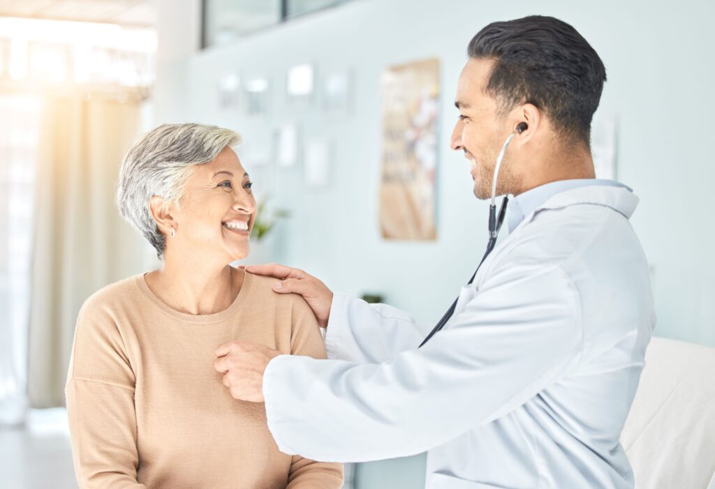 Doctor listening to woman's heart with stethoscope